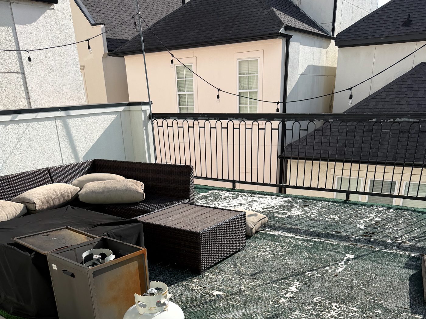 3rd floor townhome rooftop deck with worn, sun-bleached turf before replacement