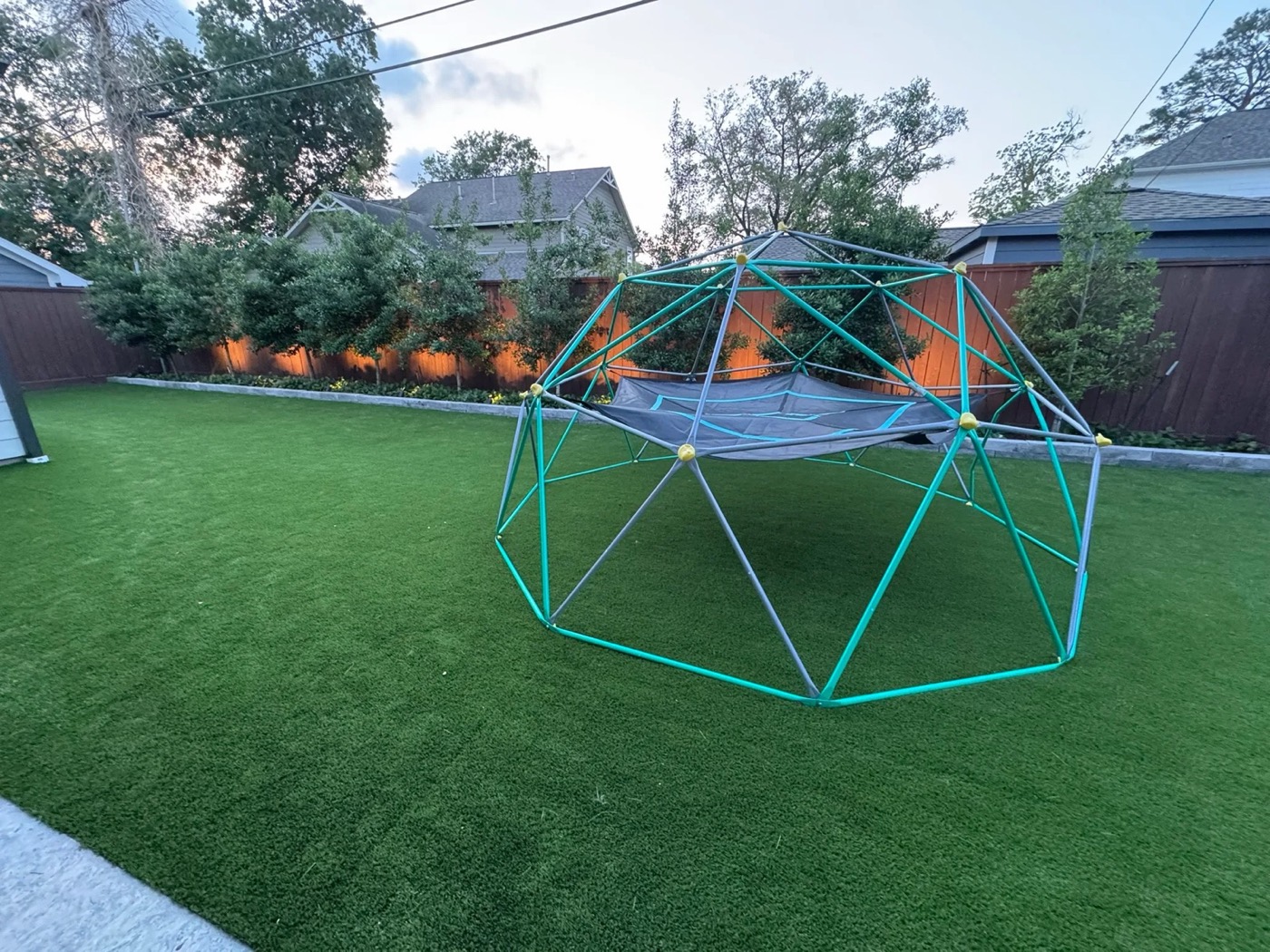 Backyard play turf with a climbing dome